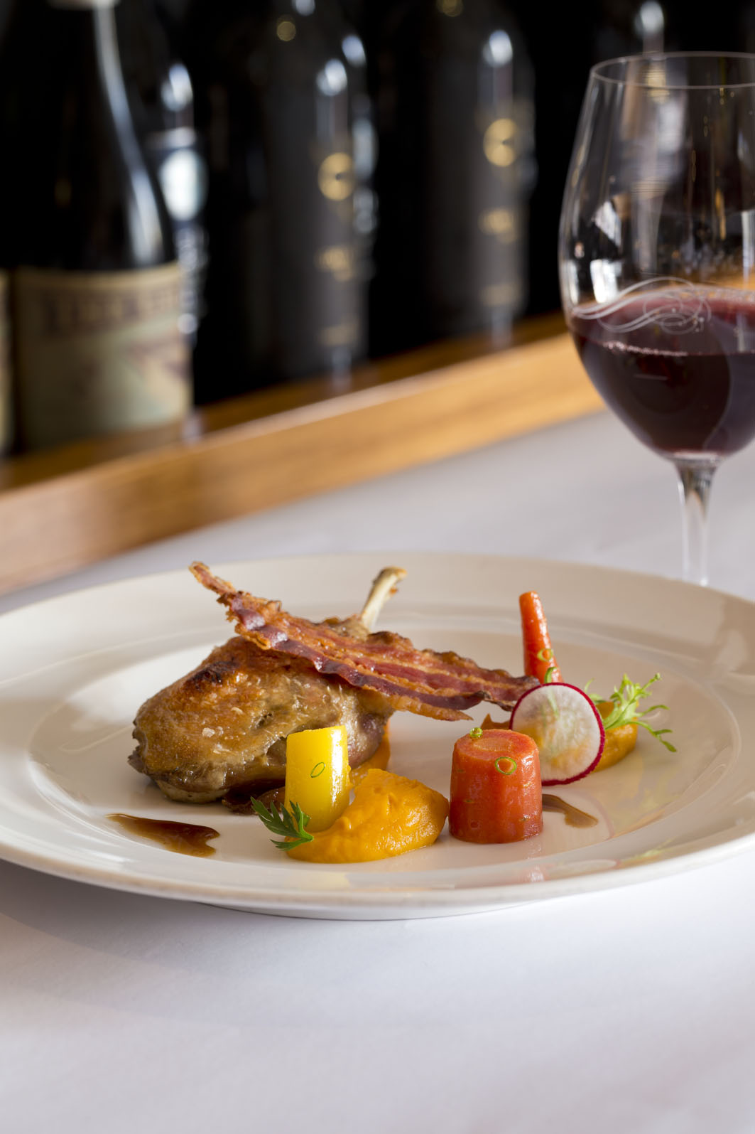 Confit duck leg, pumpkin puree, baby carrots, black pig bacon, jus | Photography courtesy of Must Winebar
